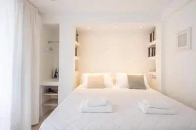 a white bedroom with a large white bed with two towels at The Room with a View in Athens
