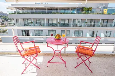 a pink table with a glass of wine and two chairs at The Room with a View in Athens