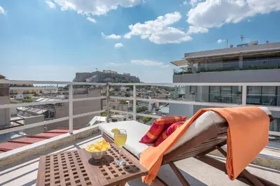 a balcony with a table and chairs on a roof at The Room with a View in Athens