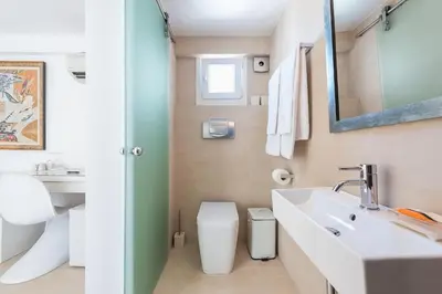 a bathroom with a sink and a toilet and a mirror at The Room with a View in Athens