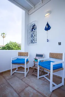 a room with two chairs and a table and a desk at Sarwnisland in Lagonissi
