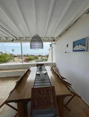 a dining room with a table and a large window at Sarwnisland in Lagonissi