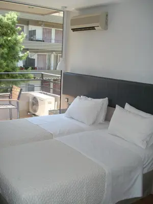 a bedroom with a large white bed with a balcony at Elements Rooms & Apartments in Athens