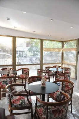 a restaurant with tables and chairs and windows at Elements Rooms & Apartments in Athens