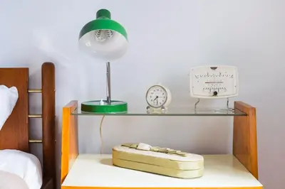 a shelf with a alarm clock and a clock on a bed at Athens Vintage Apartment - Pagrati in Athens