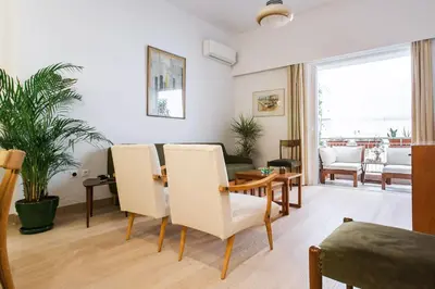 a living room with a table and chairs at Athens Vintage Apartment - Pagrati in Athens
