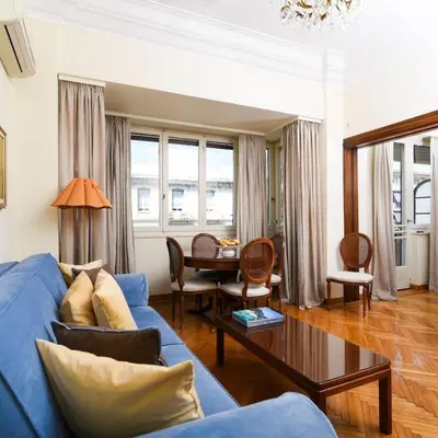 a living room with a blue couch and a table at Classy Apartment in the Heart of Athens in Athens