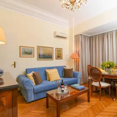 a living room with a blue couch and a table at Classy Apartment in the Heart of Athens in Athens