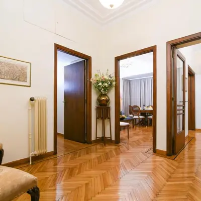 a hallway with doors and a table with a vase of flowers at Classy Apartment in the Heart of Athens in Athens