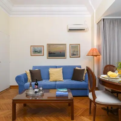 a living room with a blue couch and a table at Classy Apartment in the Heart of Athens in Athens