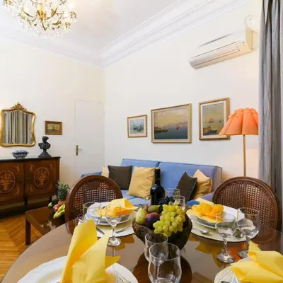a living room with a table and a blue couch at Classy Apartment in the Heart of Athens in Athens