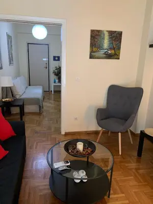 a living room with a couch and a chair and a table at Renovated cozy apartment near to Acropolis in Athens