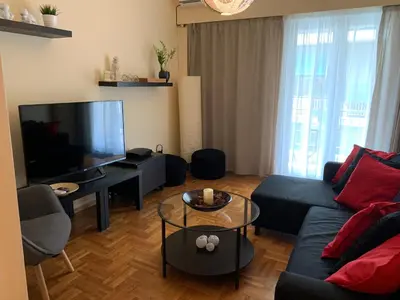 a living room with a couch and a flat screen tv at Renovated cozy apartment near to Acropolis in Athens