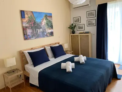 a bedroom with a blue and white bed with towels on it at Renovated cozy apartment near to Acropolis in Athens
