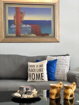 a living room with a couch with a pillow and a table at Koukaki Apt 5 min walk to Acropolis in Athens