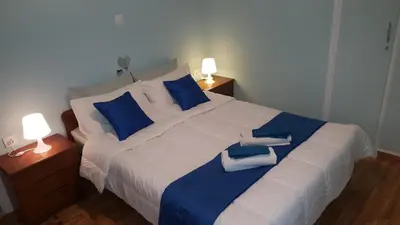 a bedroom with a large white bed with blue pillows at Koukaki Apt 5 min walk to Acropolis in Athens
