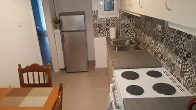a kitchen with a stove and a sink and a refrigerator at Koukaki Apt 5 min walk to Acropolis in Athens