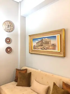 a couch in a living room with a painting on the wall at Koukaki Apt 5 min walk to Acropolis in Athens