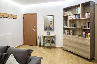 a living room with a couch and a book shelf at The Grove House in Athens