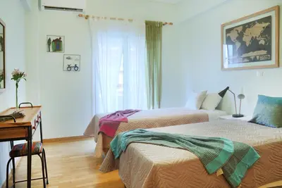 a bedroom with two beds and a desk and a window at The Grove House in Athens
