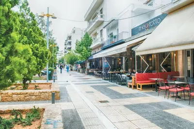 a street with tables and chairs and a building at The Grove House in Athens