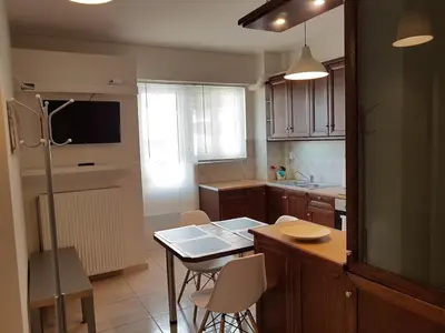 a kitchen with a table and a kitchen with a refrigerator at Errathens Zephyr Apartment - Athens Center, 3 BD, 1 BATH in Athens