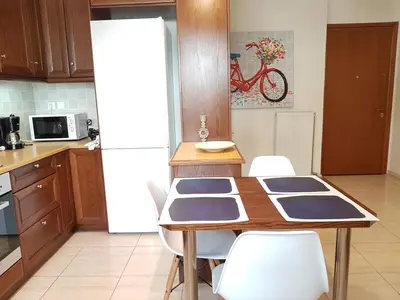 a kitchen with a table with chairs and a white refrigerator at Errathens Zephyr Apartment - Athens Center, 3 BD, 1 BATH in Athens