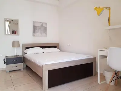 a bedroom with a bed and a lamp and a sink at Errathens Zephyr Apartment - Athens Center, 3 BD, 1 BATH in Athens