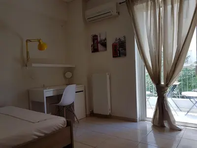 a bedroom with a bed and a desk and a window at Errathens Zephyr Apartment - Athens Center, 3 BD, 1 BATH in Athens