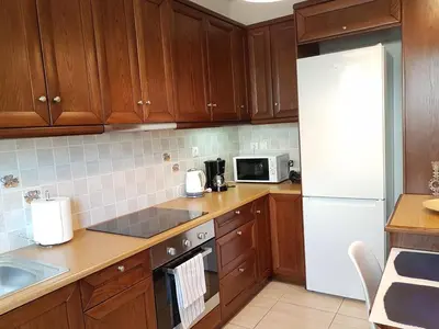 a kitchen with wooden cabinets and a white refrigerator at Errathens Zephyr Apartment - Athens Center, 3 BD, 1 BATH in Athens