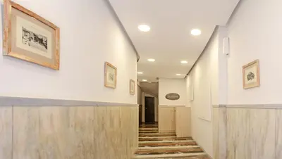 a hallway of a building with stairs and paintings on the walls at Athens Connection Apartments in Athens