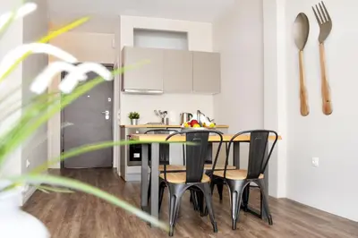 a kitchen with a table and chairs in a room at Athens Connection Apartments in Athens