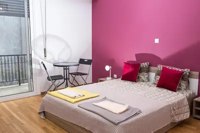 a bedroom with a bed and a purple wall at Voula's Apartment in Athens