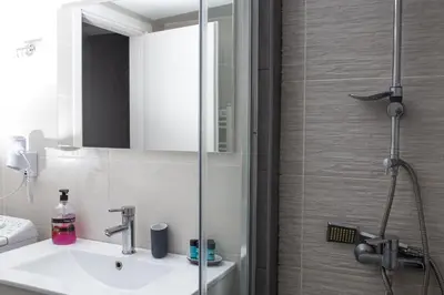 a bathroom with a sink and a shower at Voula's Apartment in Athens