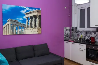 a living room with a purple wall with a couch at Voula's Apartment in Athens