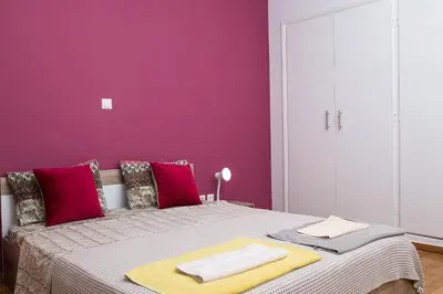 a purple bedroom with a bed with two towels on it at Voula's Apartment in Athens