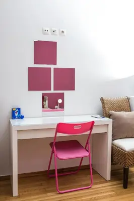 a pink chair sitting in front of a desk at Voula's Apartment in Athens