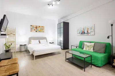 a living room with a bed and a green couch at Apartments Historical Center in Athens
