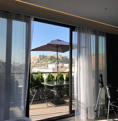 a balcony with a table and an umbrella at Acropolis Suite in Athens