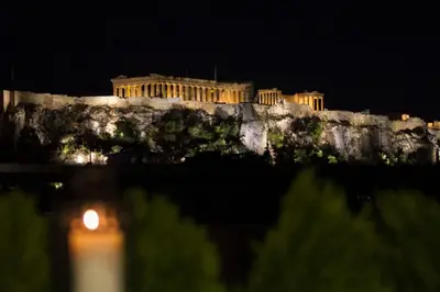 a building on top of a cliff at night at Acropolis Suite in Athens