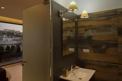 a bathroom with a sink and a mirror at Acropolis Suite in Athens