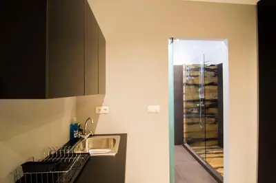 a kitchen with a sink and a counter with a mirror at Acropolis Suite in Athens