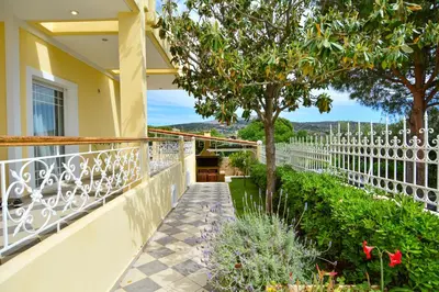 a balcony with a view of a garden at Villa Filoxenia all seasons, near airport, sea, Athens in Aghia Marina