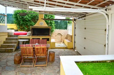 a patio with chairs and a table and a grill at Villa Filoxenia all seasons, near airport, sea, Athens in Aghia Marina