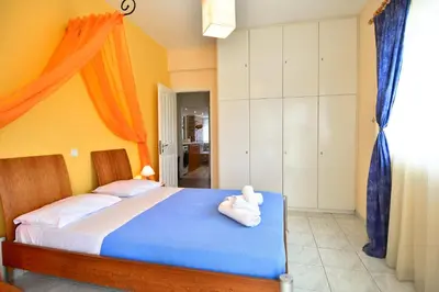 a bedroom with a bed with a stuffed animal on it at Villa Filoxenia all seasons, near airport, sea, Athens in Aghia Marina