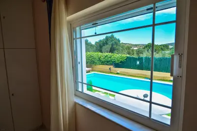 a window with a view of a swimming pool at Villa Filoxenia all seasons, near airport, sea, Athens in Aghia Marina