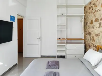 a bedroom with a white bed and white cabinets at KYMA Apartments - Athens Acropolis 2 in Athens