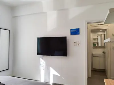 a flat screen tv hanging on a white wall at KYMA Apartments - Athens Acropolis 2 in Athens