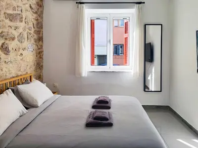 a bedroom with a bed with a mirror and a window at KYMA Apartments - Athens Acropolis 2 in Athens