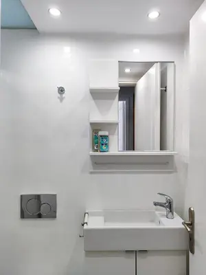 a white bathroom with a sink and a mirror at KYMA Apartments - Athens Acropolis 2 in Athens